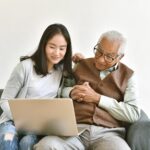 Daughter and elderly father using laptop computer together, Senior people spend time learning to use social media and digital technology platform, Asian family relationship.